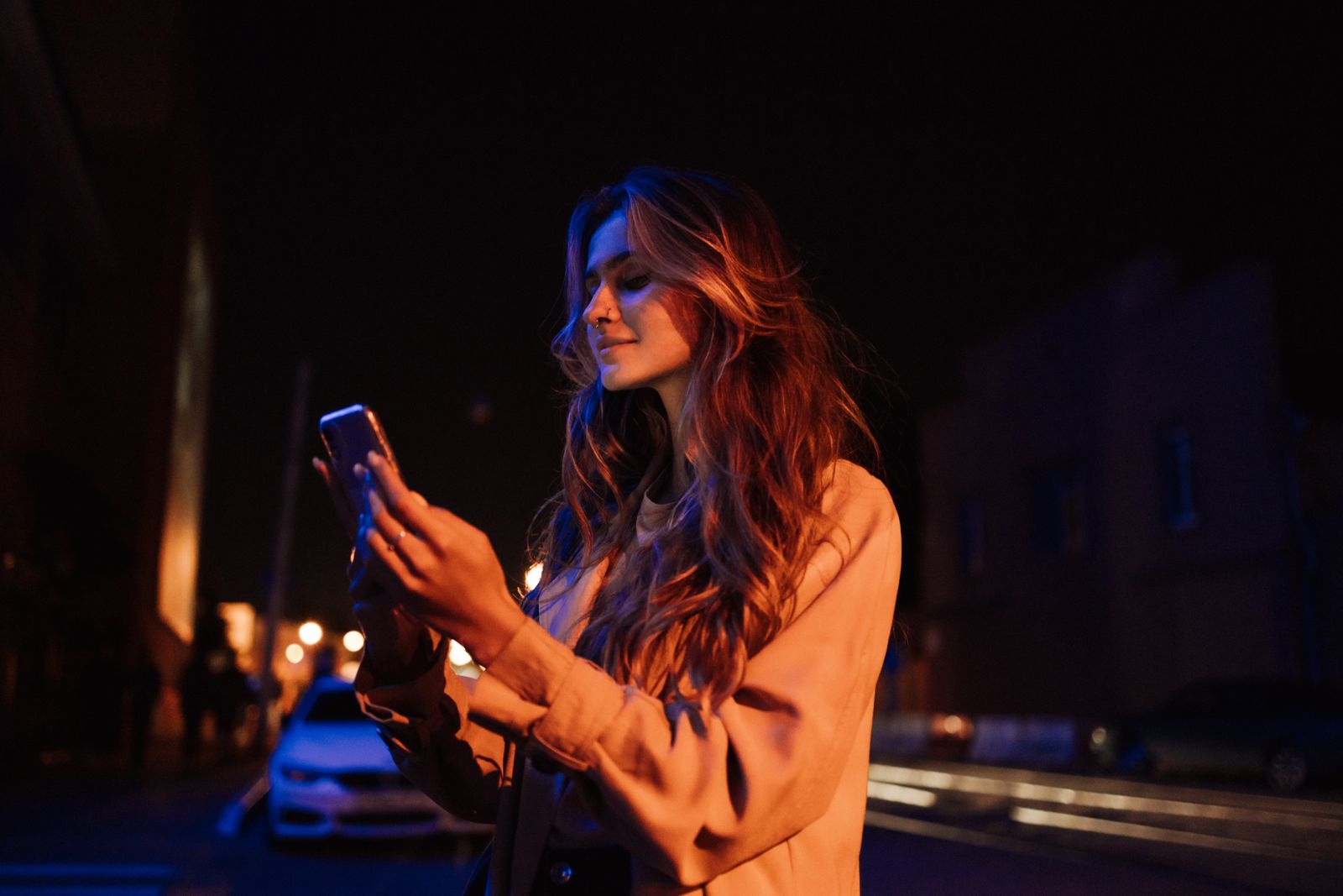Une femme regarde son téléphone, seule, le soir
